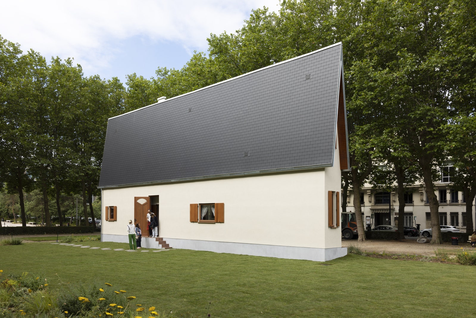 Image may contain Architecture Building Cottage House Housing Grass Plant Outdoors Shelter Person and Car