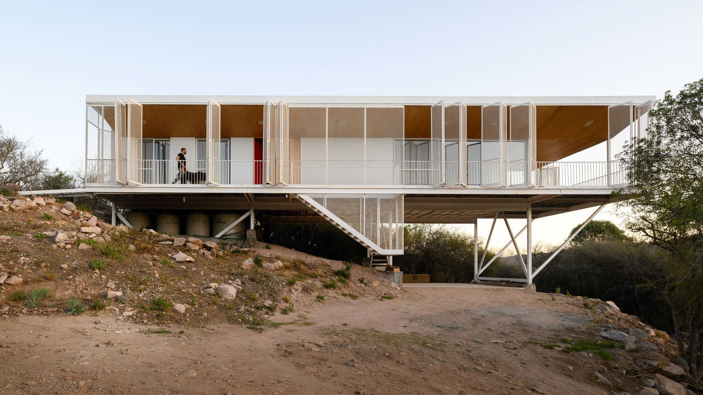A person walking along an elevated walkway around a house