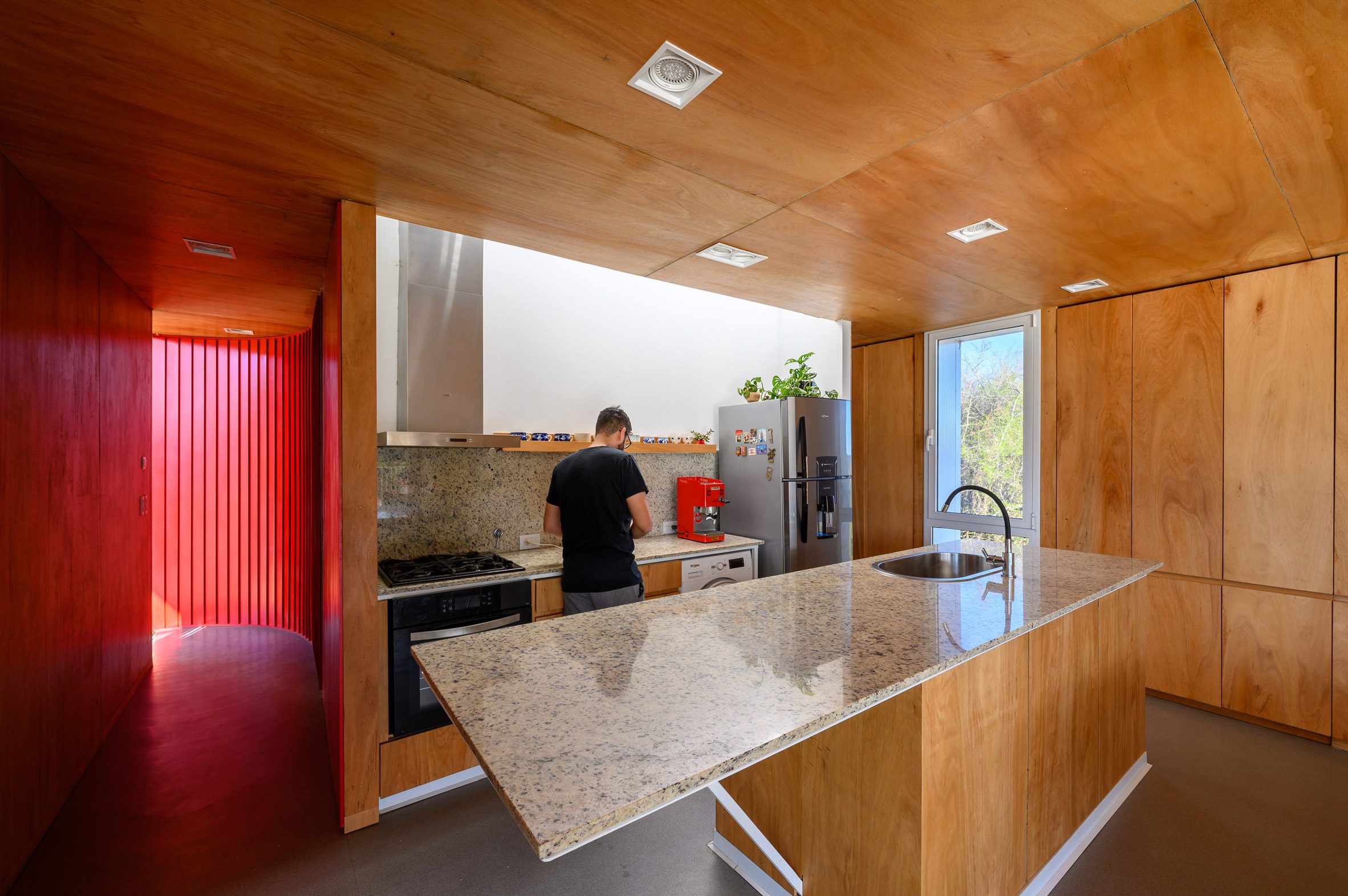 A person in a kitchen with wood cabinetry