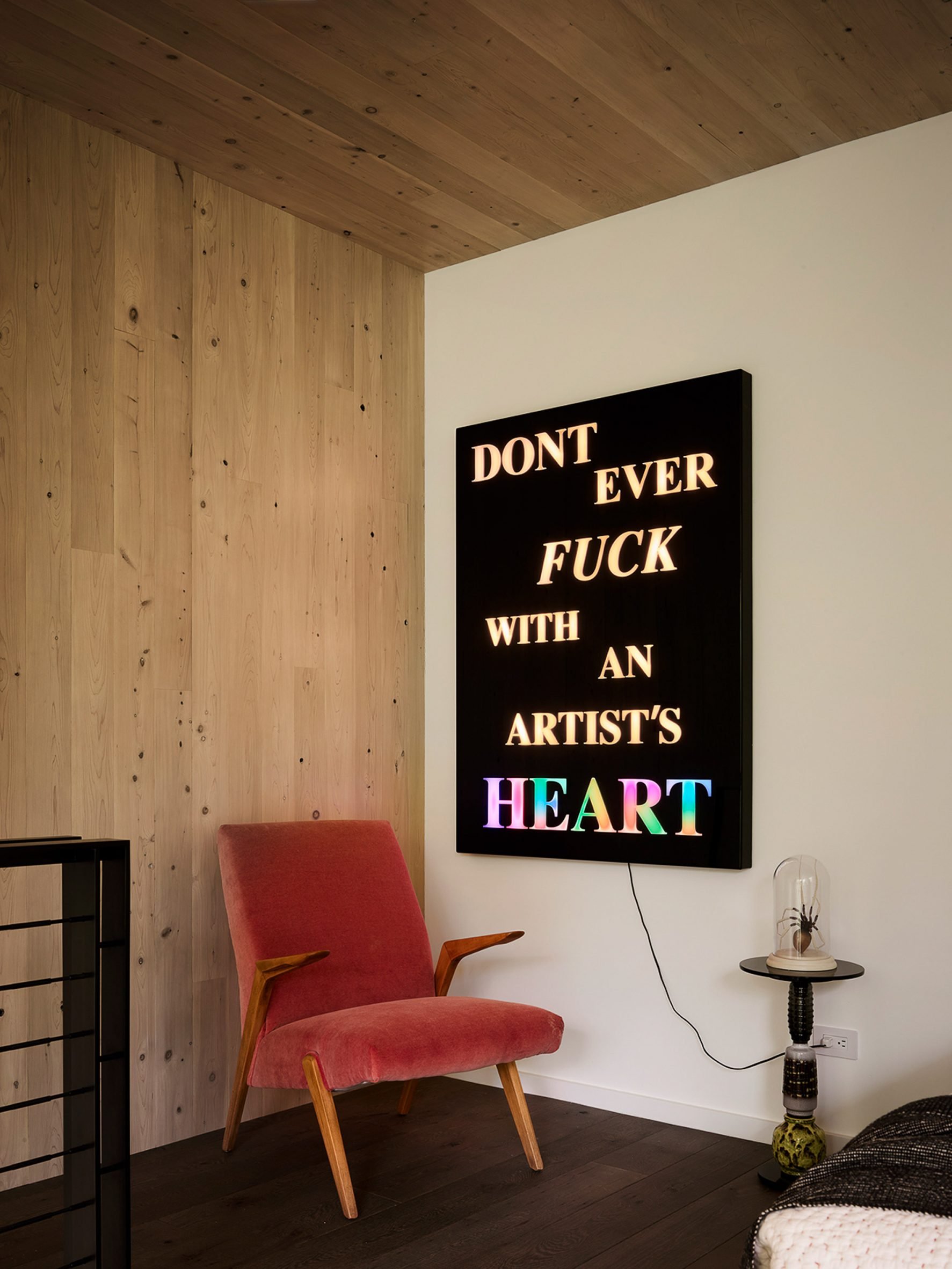 A sign on a wall with red chair
