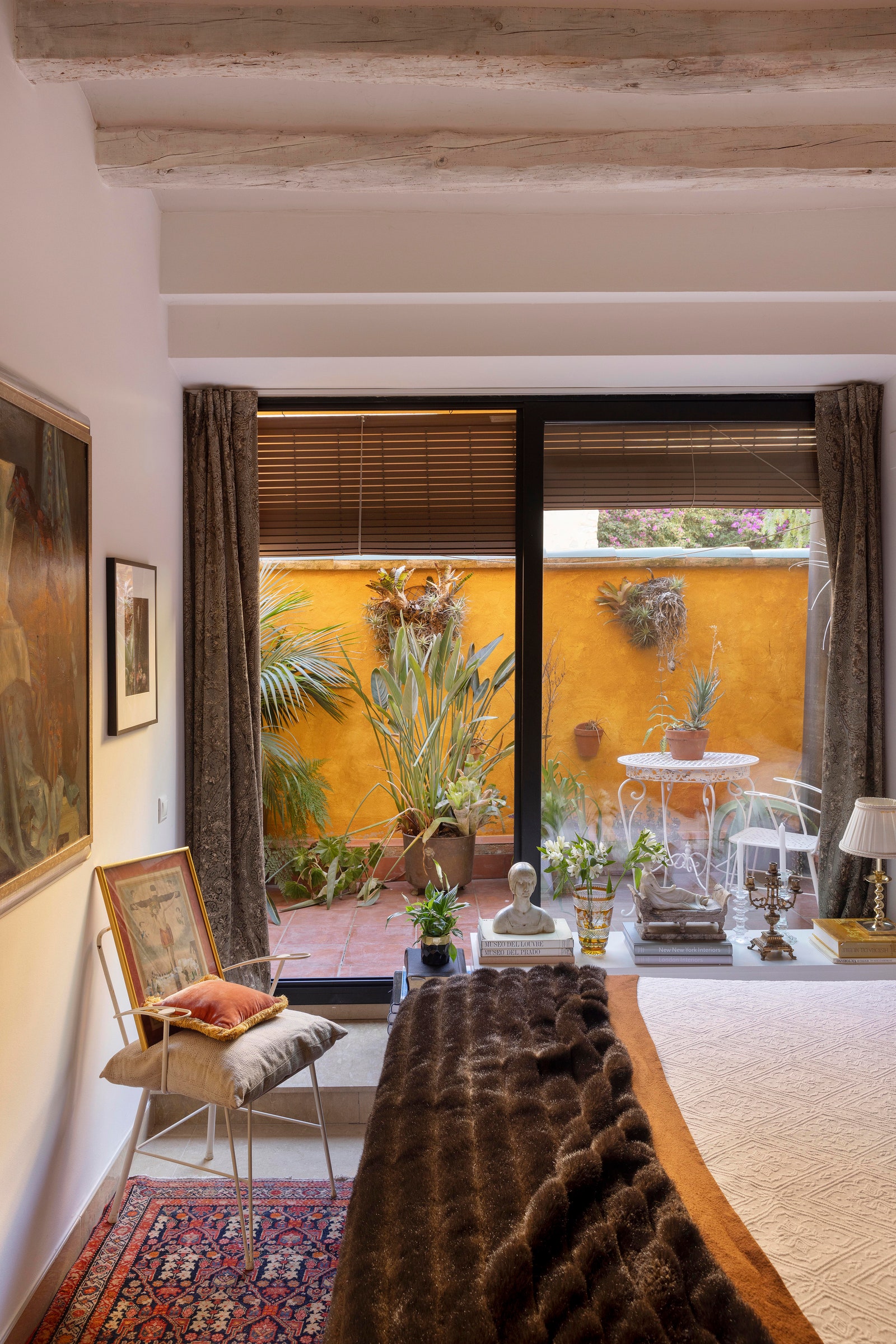 Image may contain Home Decor Rug Chair Furniture Lamp Plant Person Art Painting Architecture Building and Indoors