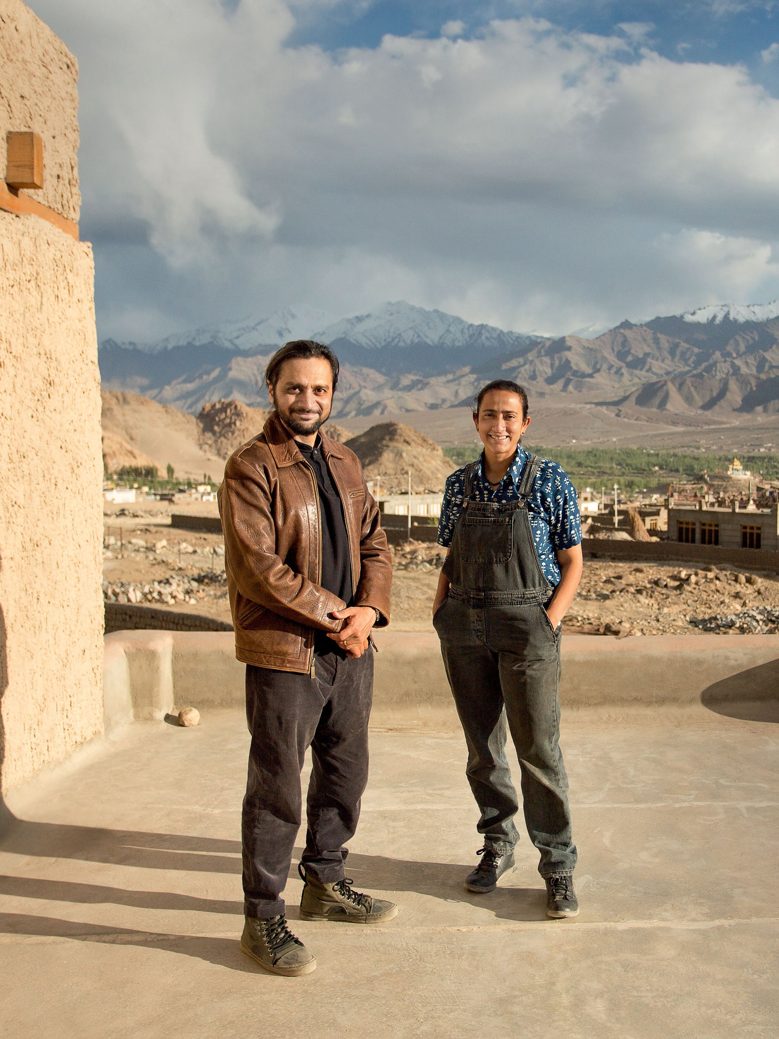 two people standing in a mountainous region