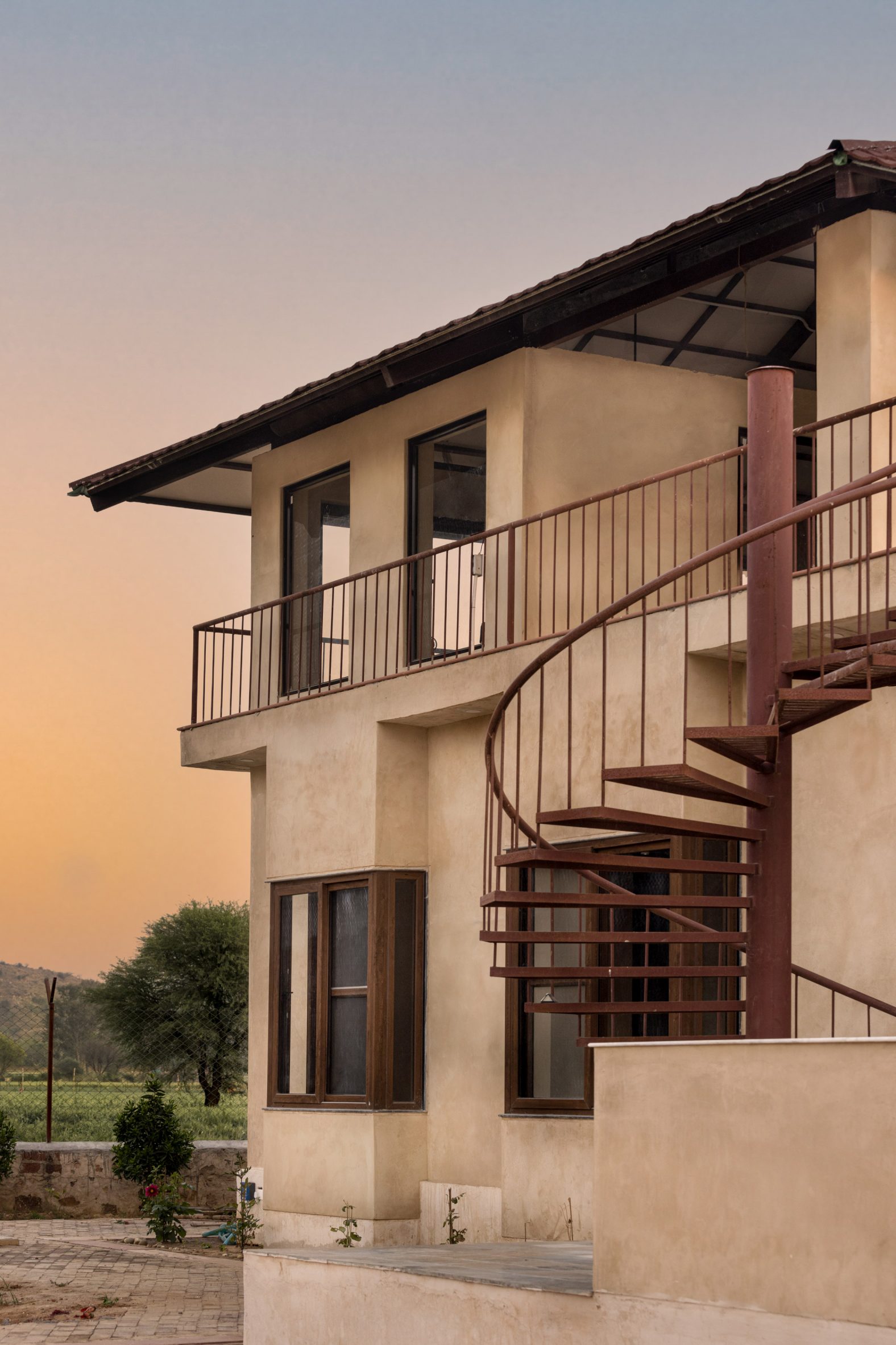 Exterior of Stone House by Sketch Design Studio with spiral staircase