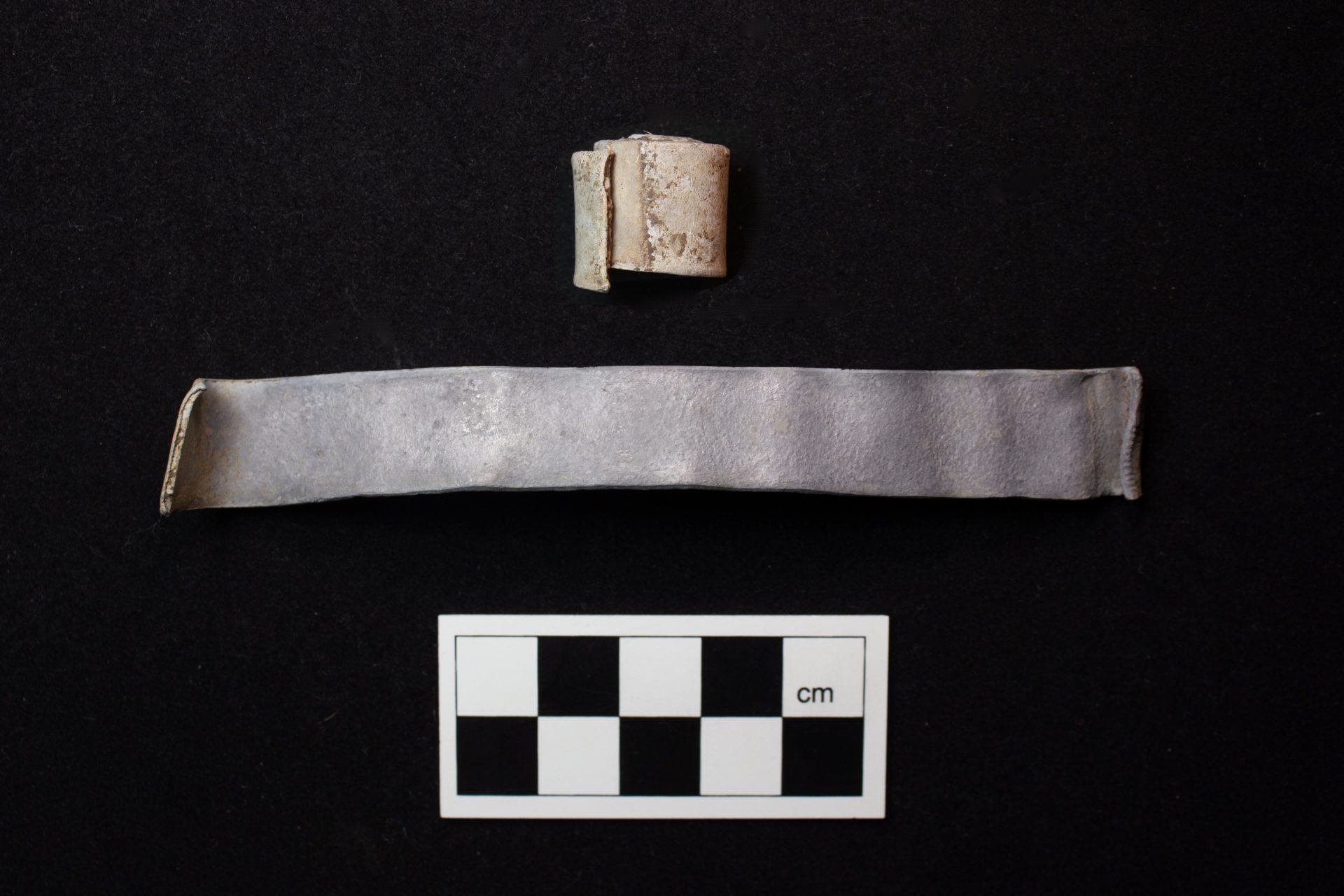 A small unrolled scroll and a rolled one.