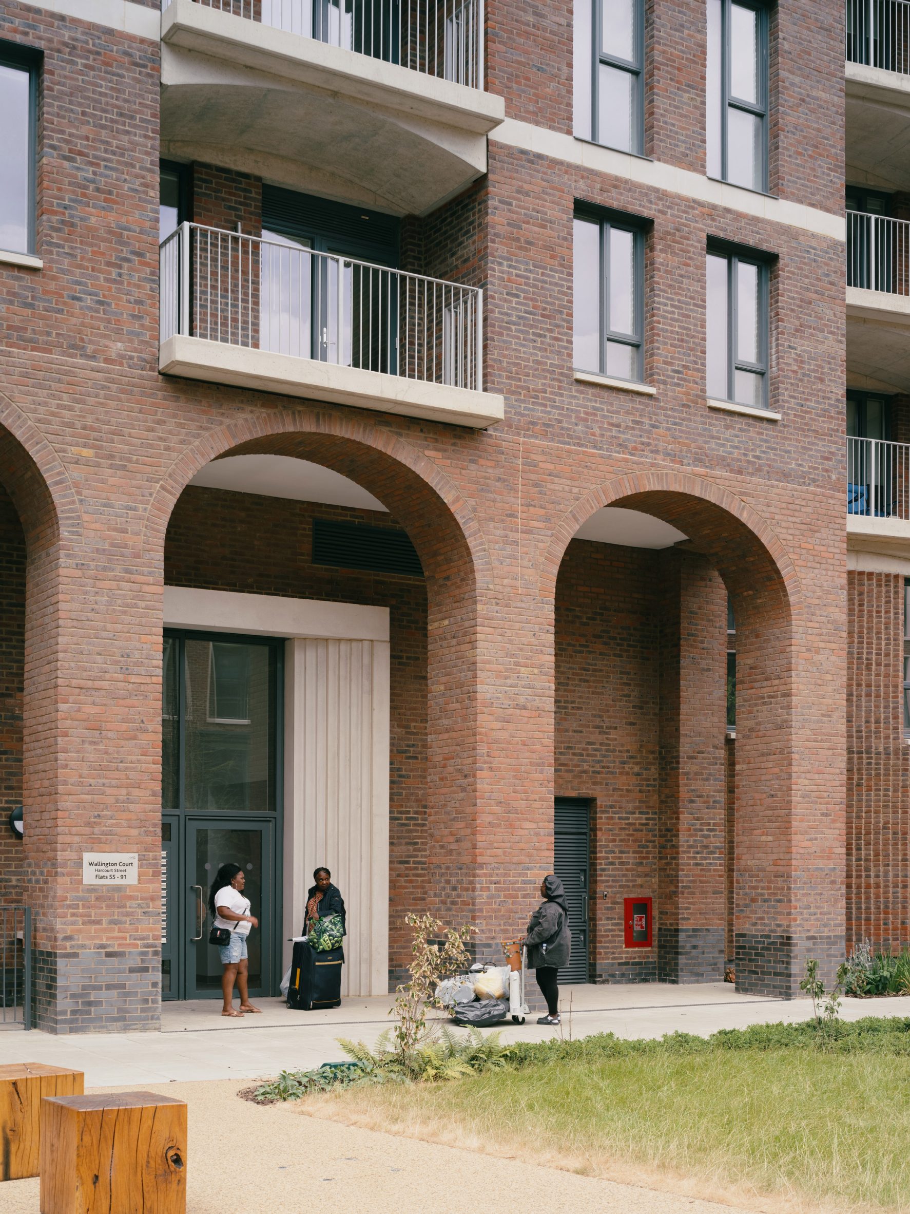 People gathered outside new housing block by Mae Architects
