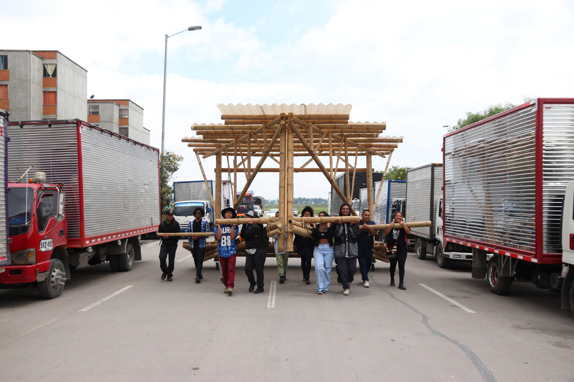 People carrying a bamboo structure