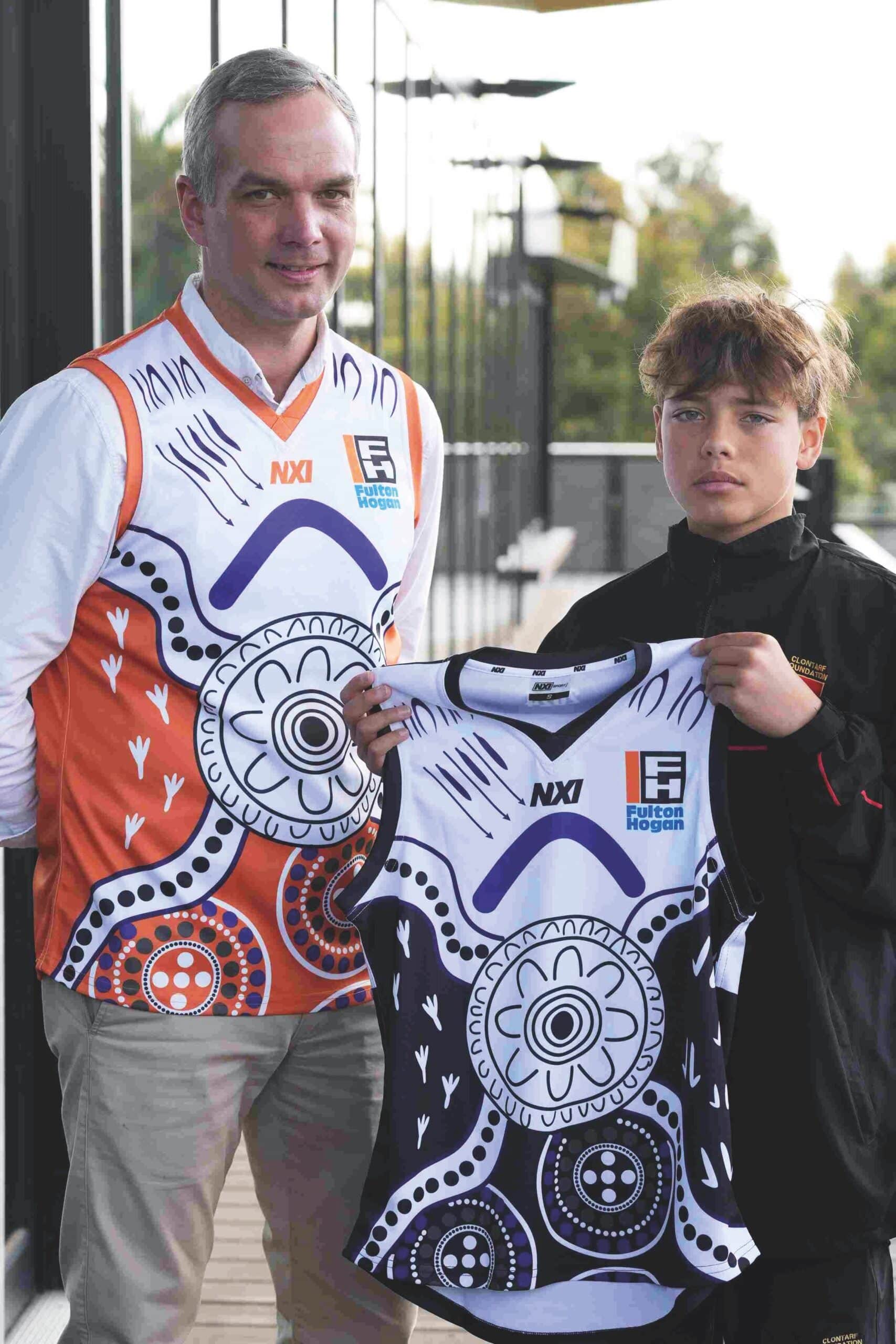 Fulton Hogan Australia CEO Graeme Johnson and Clontarf student Cliffy War at the Fulton Hogan & Clontarf NAIDOC Football Cup 2024 in Adelaide, SA, pictured with the game-day guernsey that War designed. Image: Fulton Hogan.