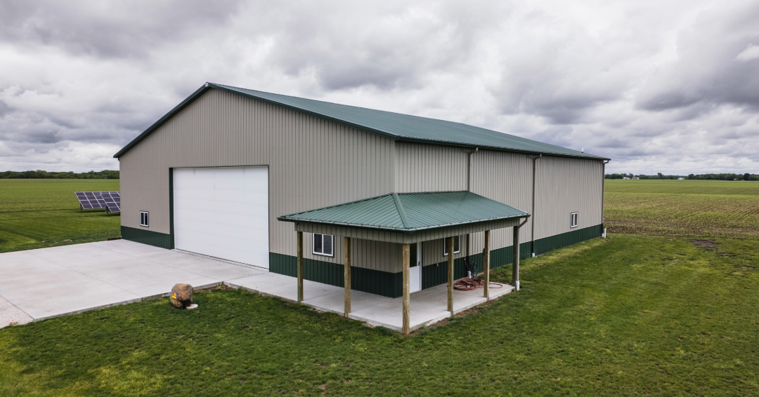 A tan and green farm shop with solar panel