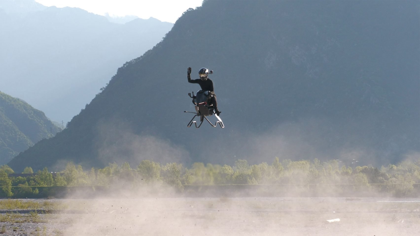 Person waving from flying hovercraft 
