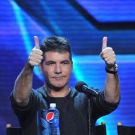 Simon Cowell holding two thumbs up