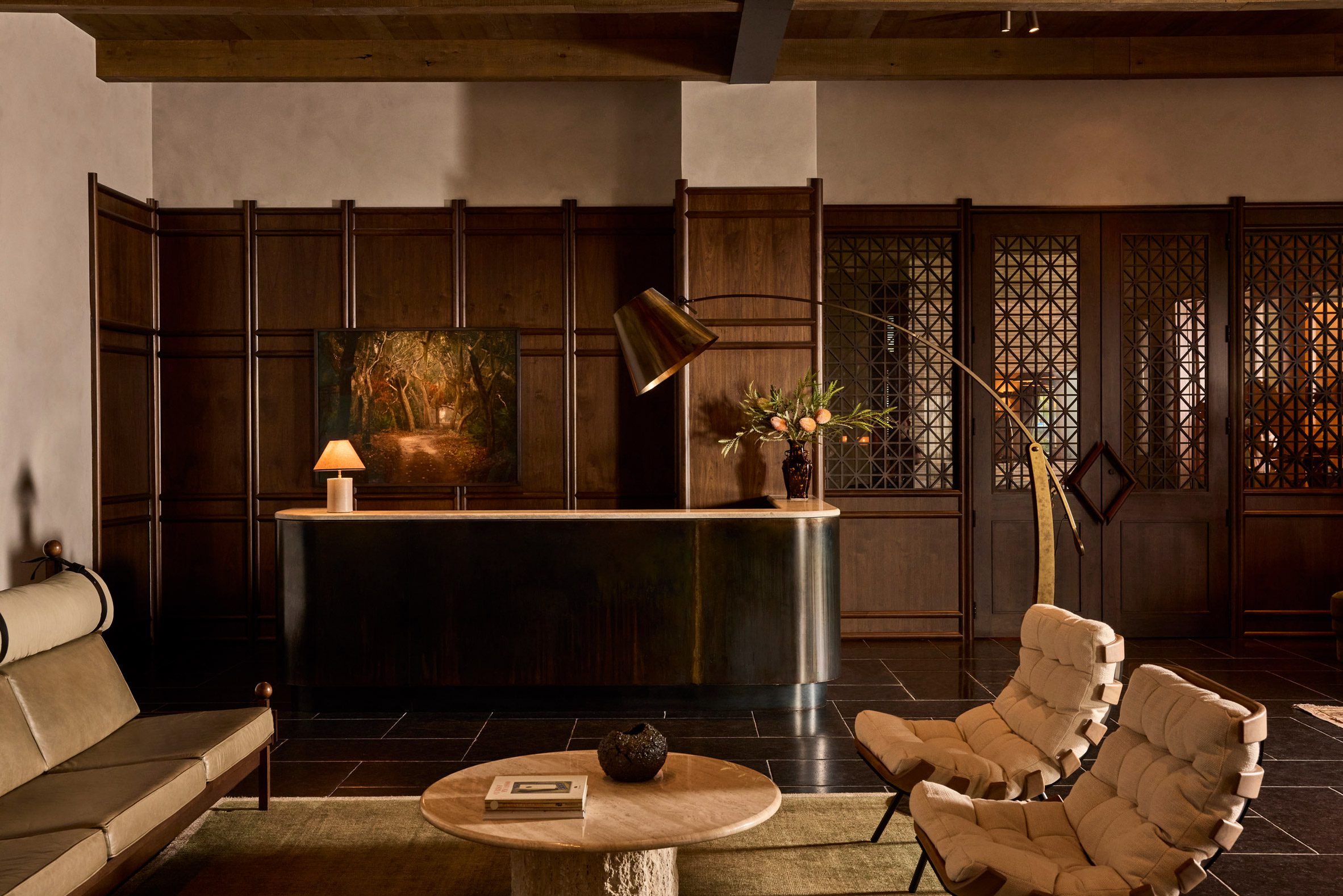 Dark wood panelling installed against textured plaster across a hotel lobby's walls