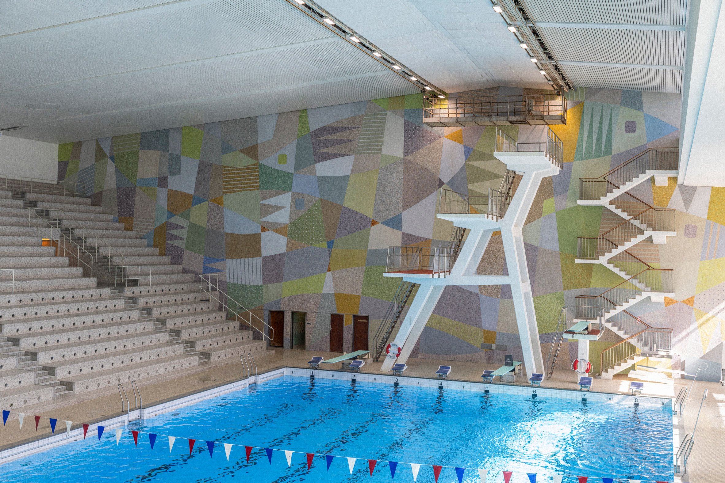 Large swimmign pool in front of mural