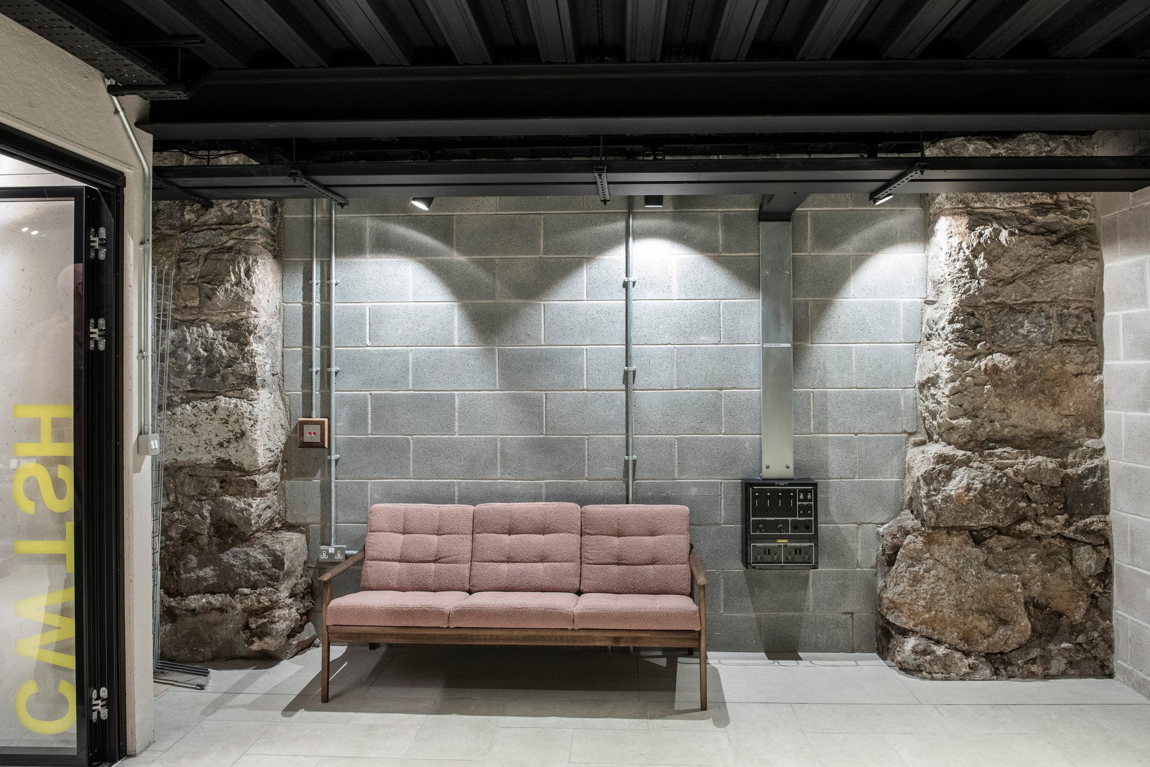 Stone walls and sofa inside youth arts hub