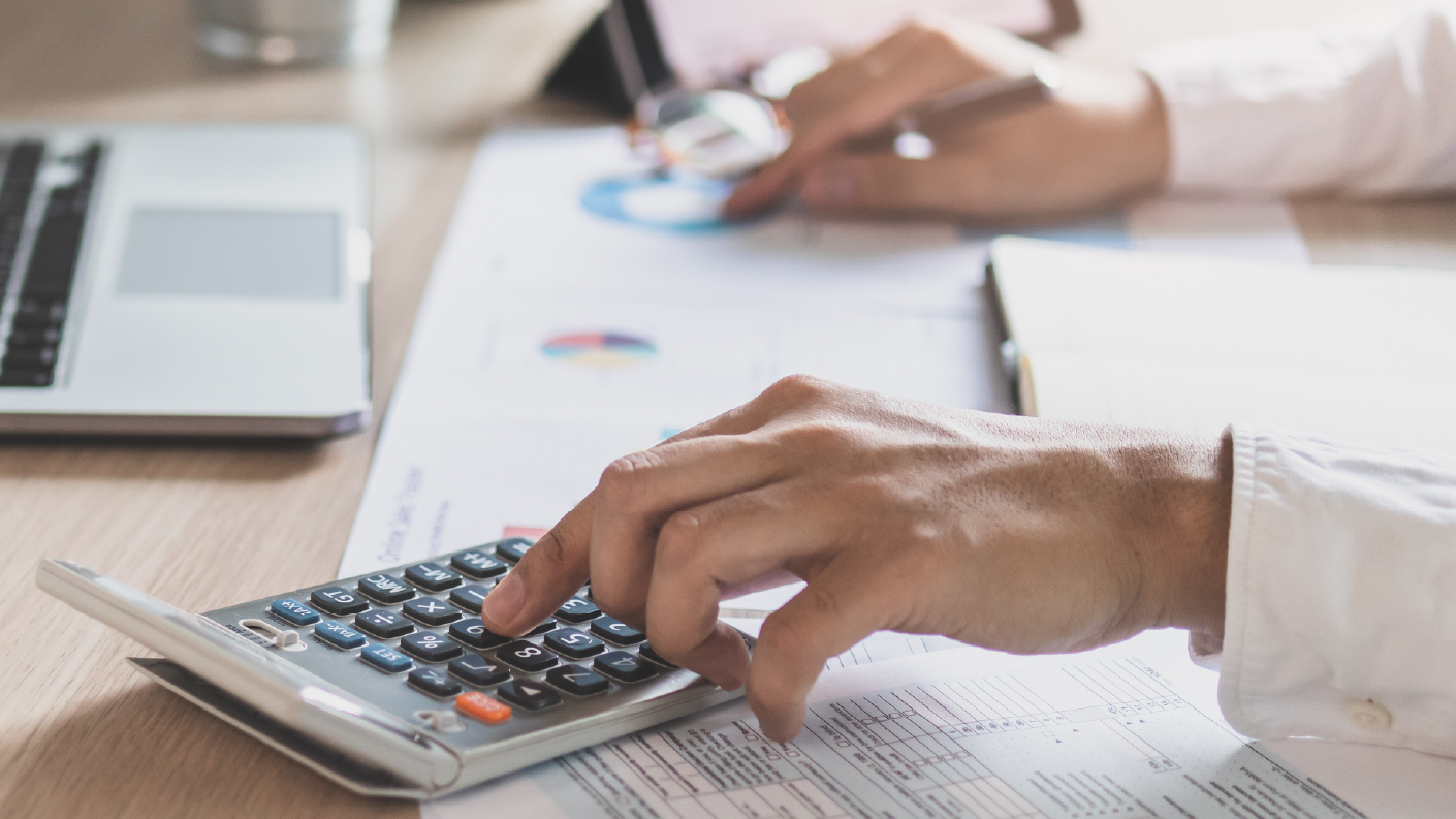 Person typing on calculator